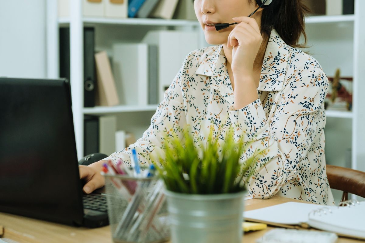 woman using a headset is on a video call on her laptop