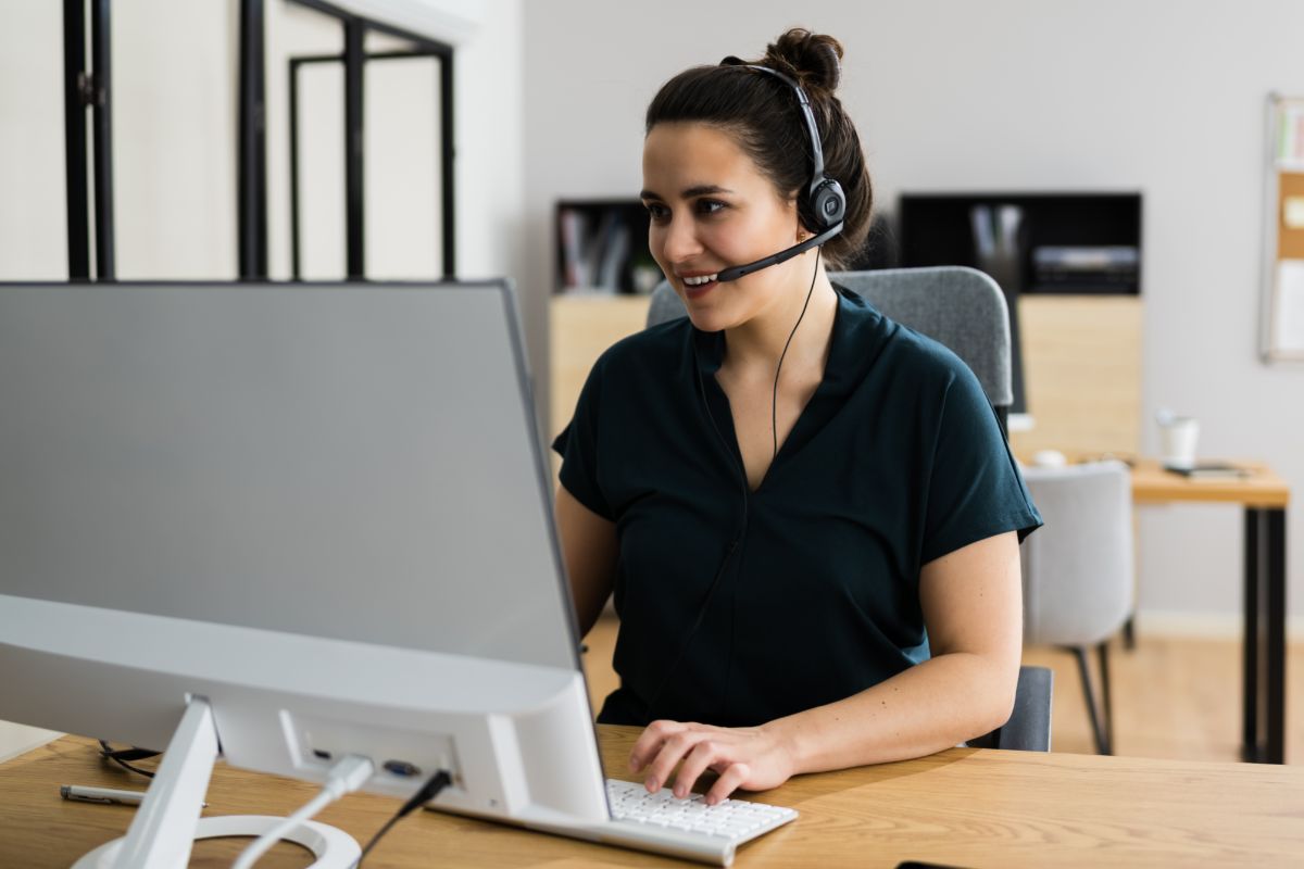 woman wearing black and a headset is on a video call with her client