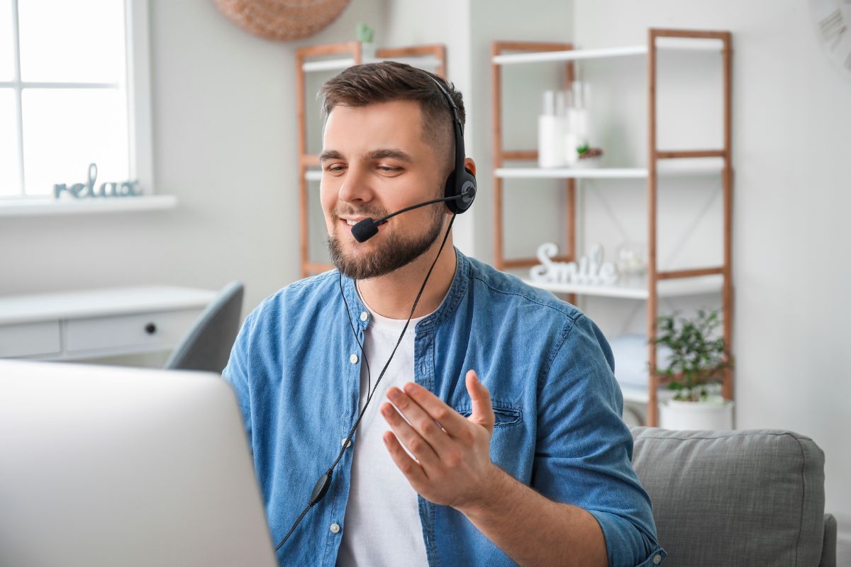 man in a blue shirt wearing a headset talking to a client