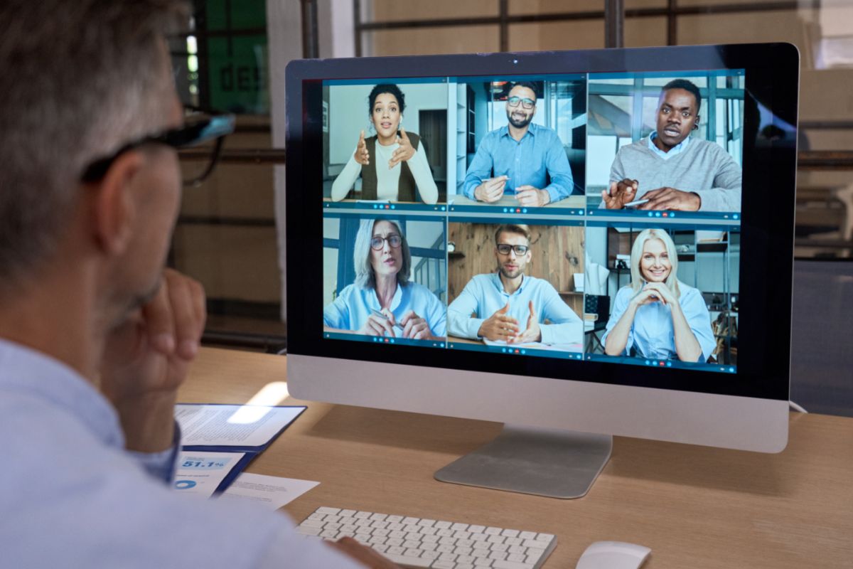 man in a blue shirt attending a video meeting