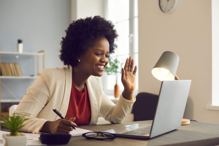 curly haired woman looking at her computer in her office