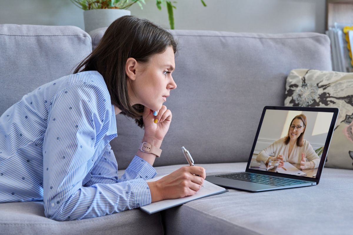 woman taking notes on her video call with a client