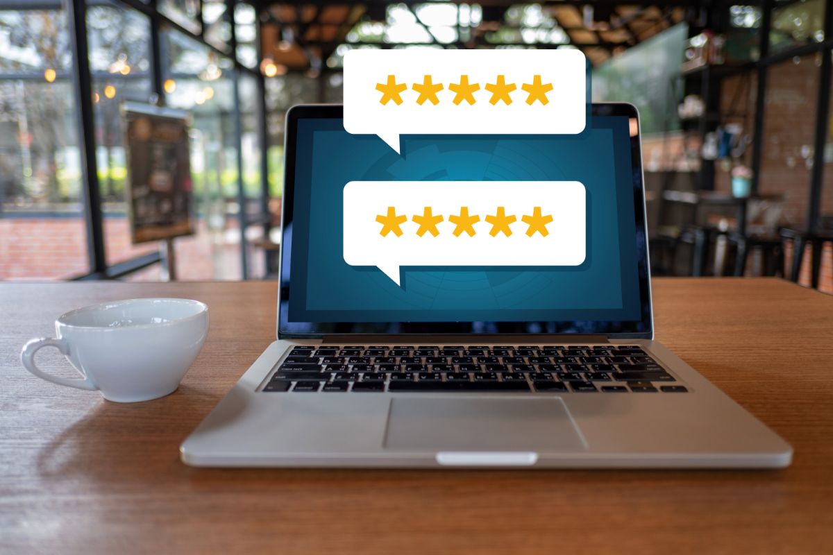 laptop on a table displaying review stars on the screen