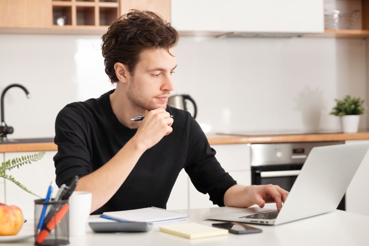 man in a black shirt on a laptop working remote