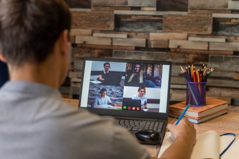 Man looking at a screen with meeting members on a video call