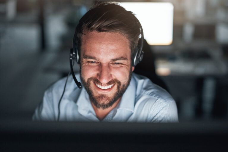 Shot of a young call center agent working on a computer in an office at night