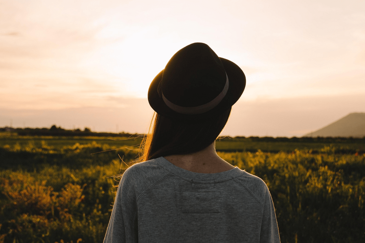 woman with a hat looking a the country side